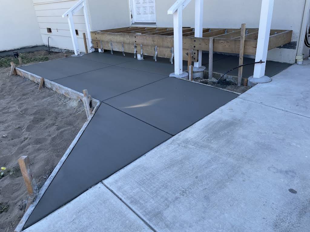 Freshly finished concrete landing beside a home