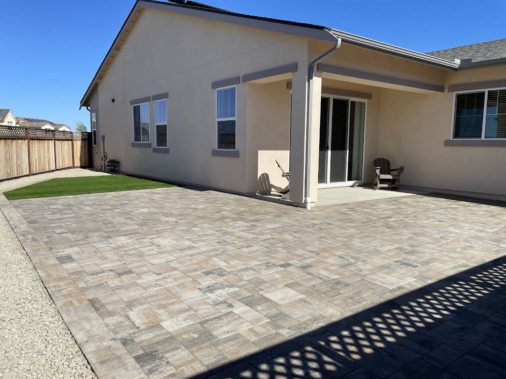 Finished paver patio beside a residential home